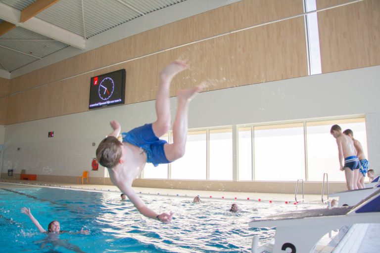 Jongen springt in zwembad Tijenraan