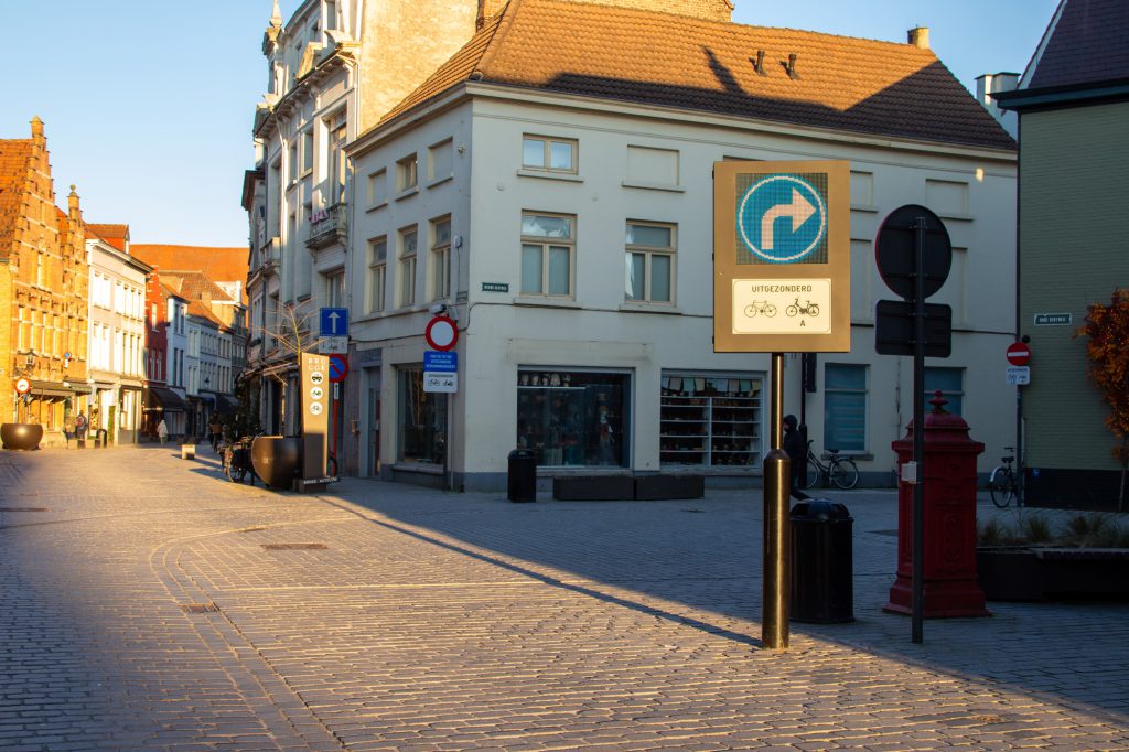 Straat met gebouwen en een dynamisch verkeersbord waarop de pijl naar rechts gaat