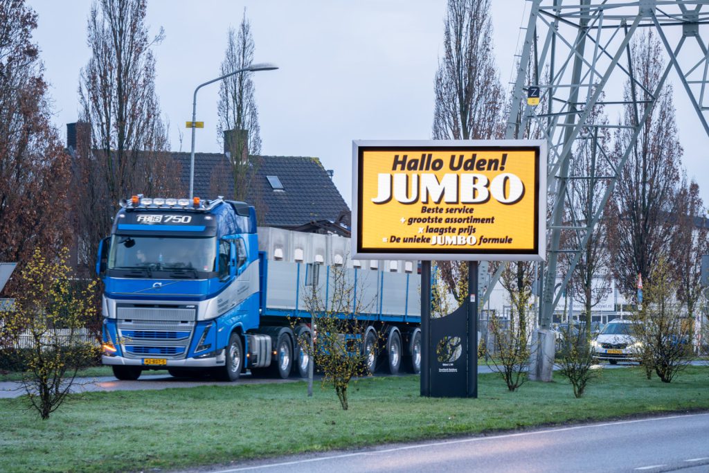 Reclamescherm toont reclame van Jumbo naast de weg.