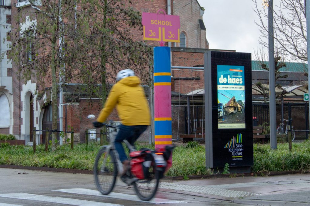Fietser rijdt langs digitale infozuil in Sint-Katelijne-Waver
